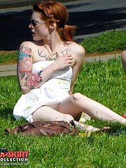 Tattooed redhead voyeured in a park. Sexy upskirt