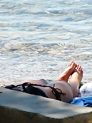 Bikini voyeur man working on beach up skirt pic