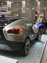 Girls in tiny shorts look great near the luxurious cars